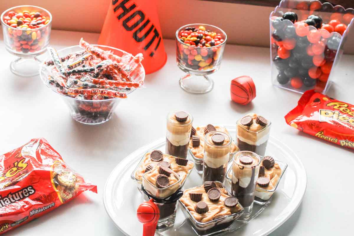 Dessert Table for a Basket ball party featuring peanut butter chocolate parfaits