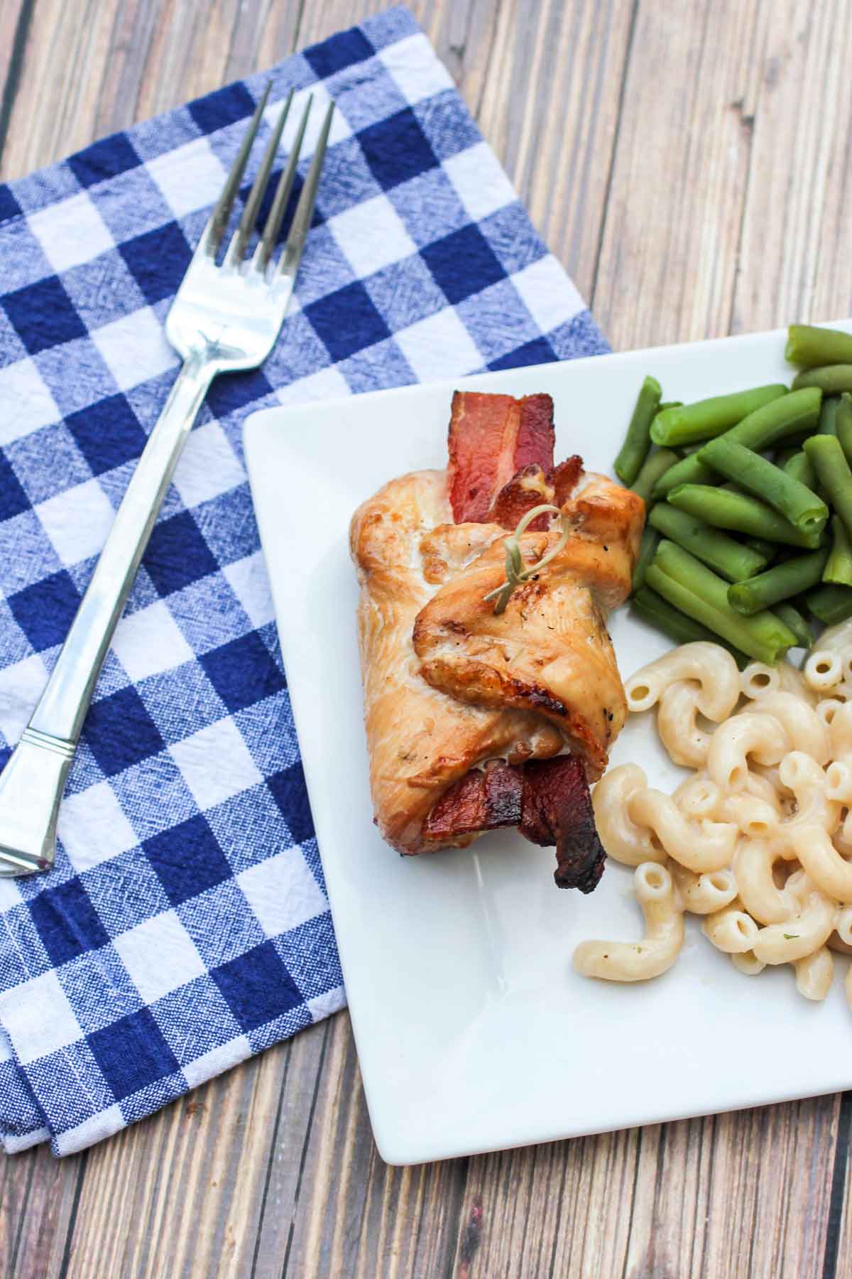 Cheesy Jalapeno Bacon Chicken Roll Ups on Plate with Checkered Napkin and Fork