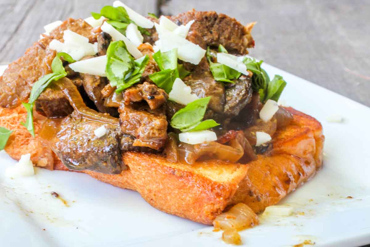Vertical Image of Open Faced Steak Sandwich on white plate