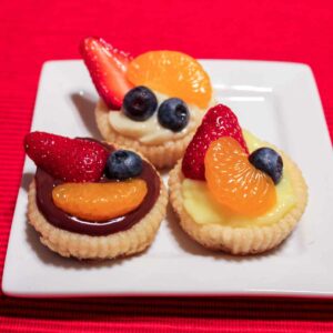 Three Pudding Fruit Tarts on a white plate