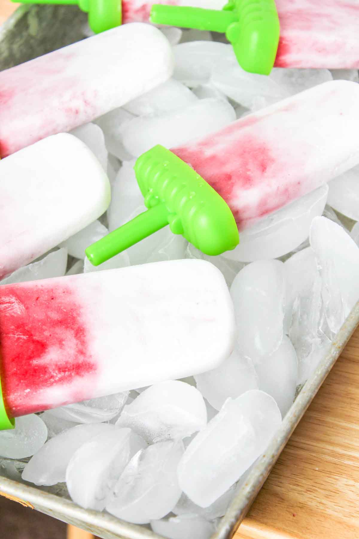 Close up shot of Strawberry Coconut Ice Pops on a tray with ice
