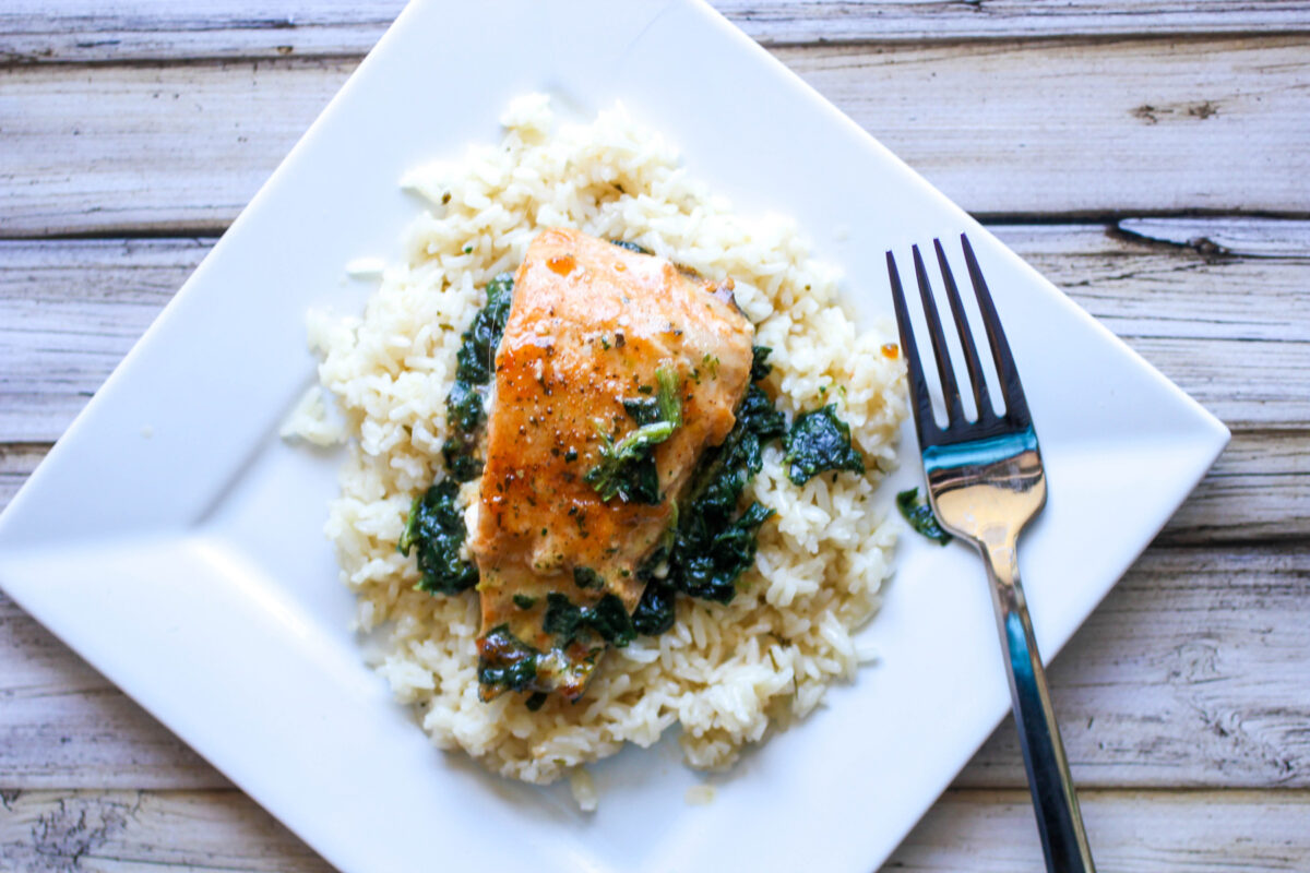 delicious garlic butter spinach and salmon on a bed of rice